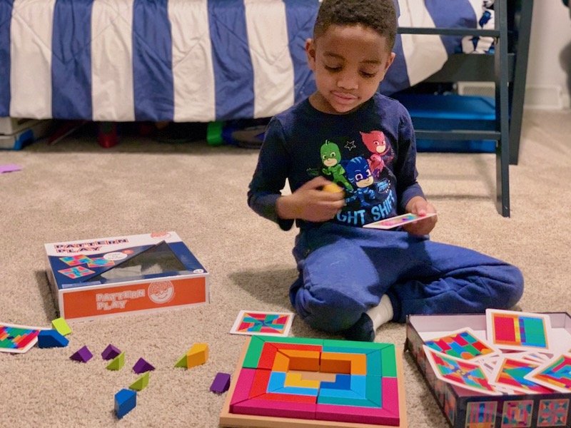 CLL playing with a brightly colored puzzle on the floor. Pattern puzzle for encouraging a pre-K child.