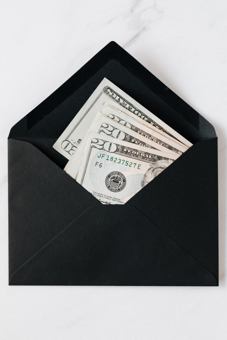 Black envelope on a white and gray background, containing multiple folded 20 dollar bills