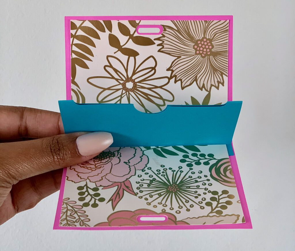 The inside of a teachers gift card holders made with Cricut machine. Pink and gold flowers on the card and the inside holder is blue.