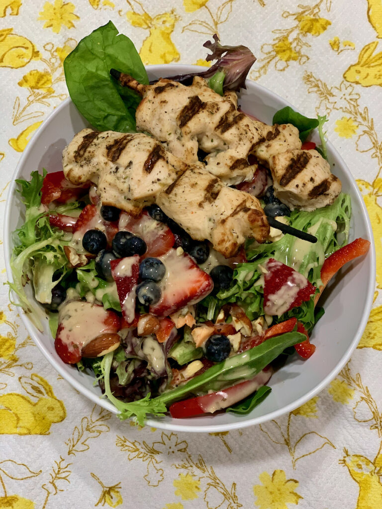 Green goddess chicken and berry salad on yellow bunny tablecloth